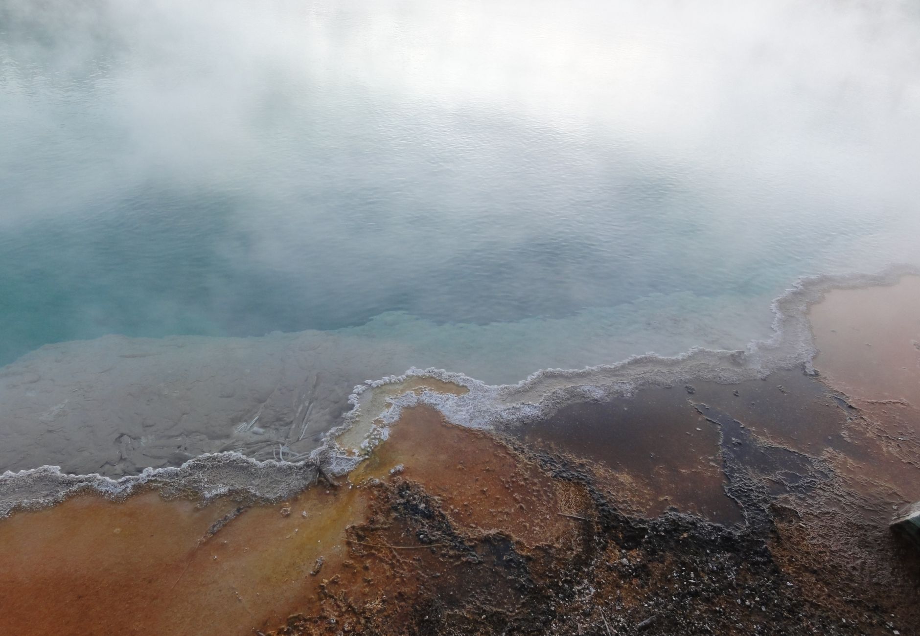 A mesmerizing view of a steaming geothermal pool in Yellowstone National Park, USA.